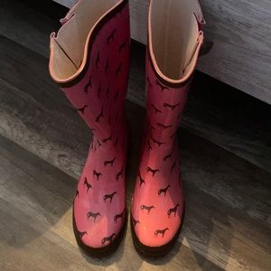 Pink rain boots with brown horses on them